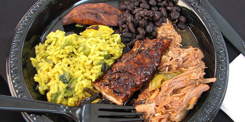 Image of a plate of smoky Jerk Chicken with rice and peas, a famous food in Jamaica.