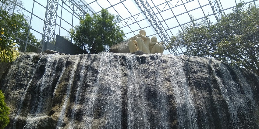 A small man-made waterfall surrounded by greenery at Jurong Bird Park in Singapore.