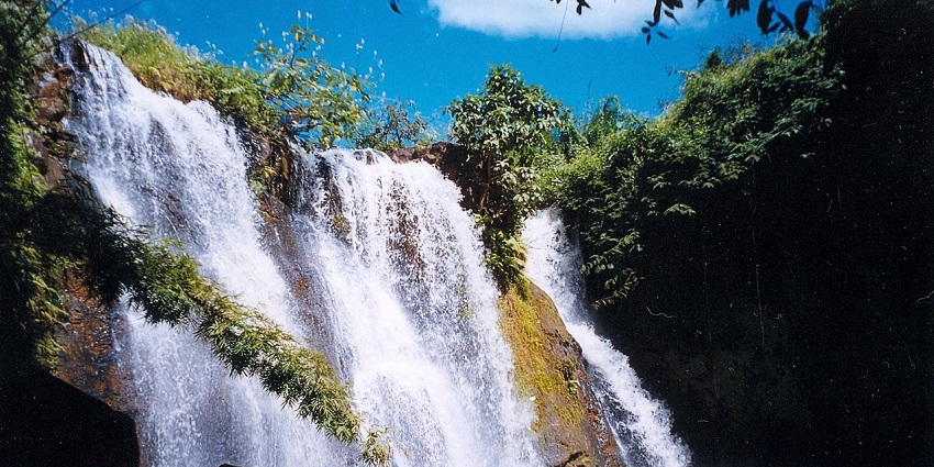 Water falling rapidly from the Ka Choung Waterfall, surrounded by greenery in Krong Ban Lung, top waterfalls in Cambodia