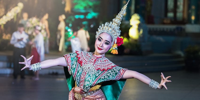A dancer in a traditional costume performing during a Thai festival with graceful movements