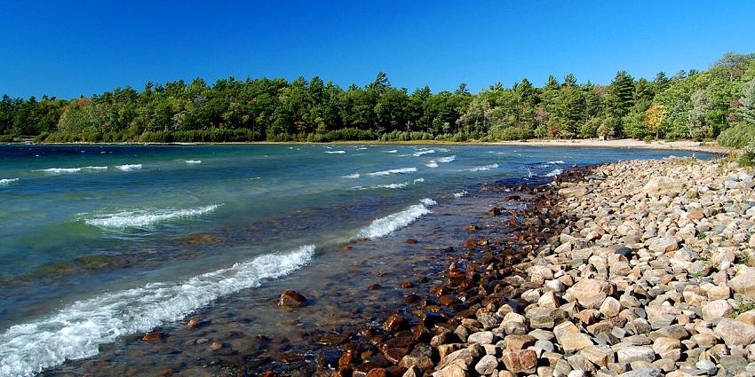 A stunning lakeside park with rocky shores, sandy beaches, and winding forested trails.