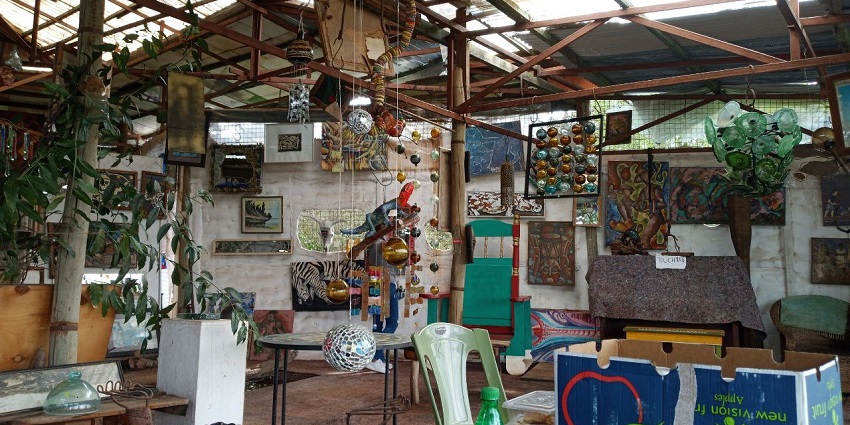 A colorful eco-art center featuring recycled glass art, suspension bridges, and artisan workshops.