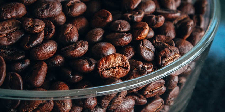 A bowl filled with rich Kona coffee beans on a table, a must-have among things to buy in US.