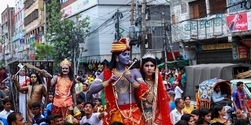 Street folk parade with performers in costume, celebrating festivals in Bangladesh.