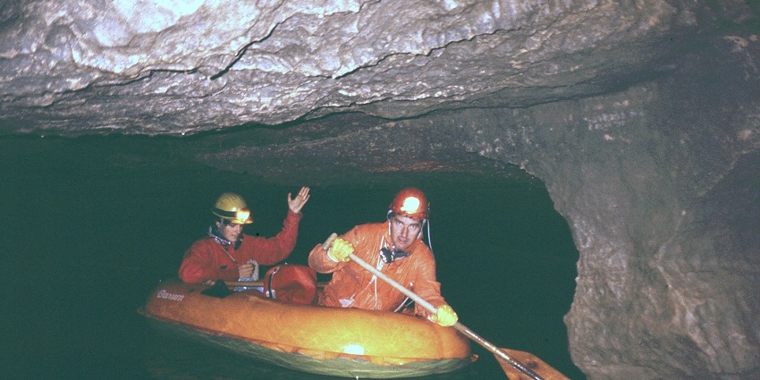 An image of a boat in a passage inside the Krizna Jama, Slovenia Cave, highlighting the cave's underground waterways.