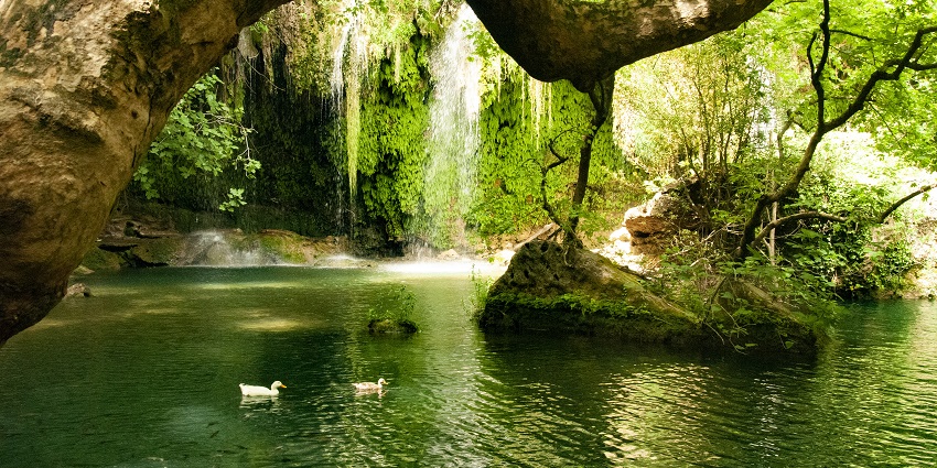 Kursunlu waterfall flowing down and two ducks floating in the pool, reflecting greenery.
