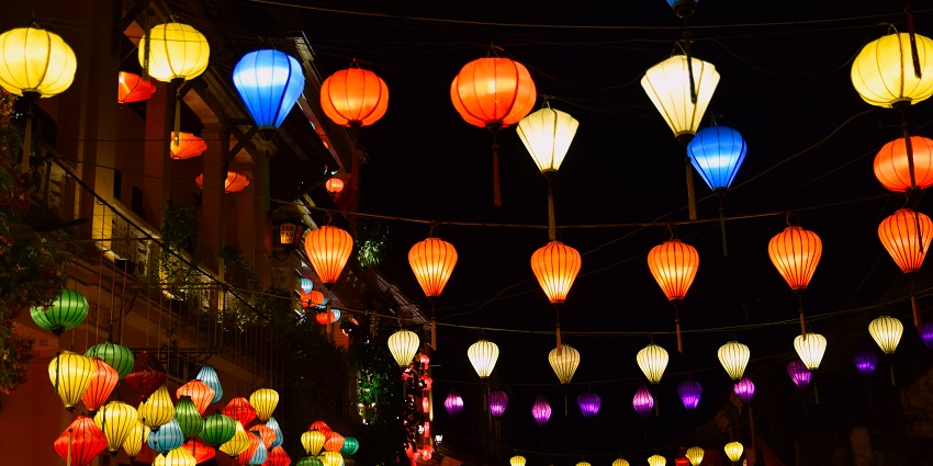 Colorful lanterns hanging and lighting up the street at night during a cultural celebration.