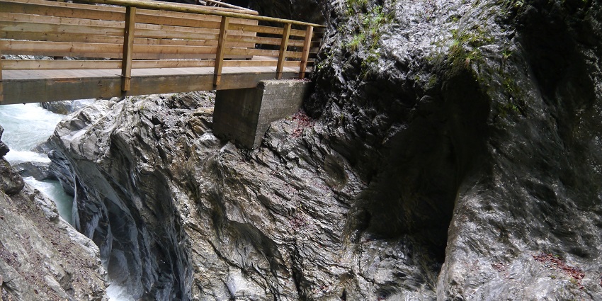 A narrow valley with a waterfall pouring over the granite rocks of Liechtensteinklamm.