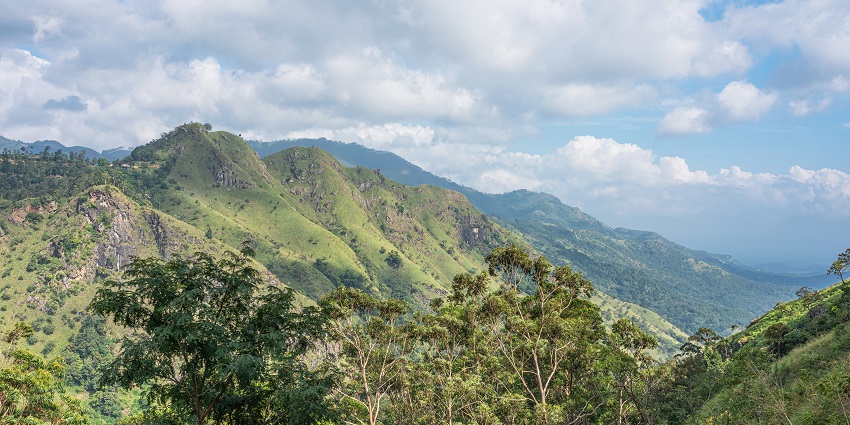 A close-up view of Little Adam’s Peak from Ravana Cave Trail, surrounded by lush greenery.