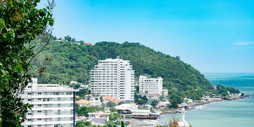 Beautiful coastline of Vung Tau with buildings and lush trees alongside
