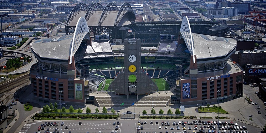 Lumen field with modern architecture, signages, a tall American flag and multiple vehicles