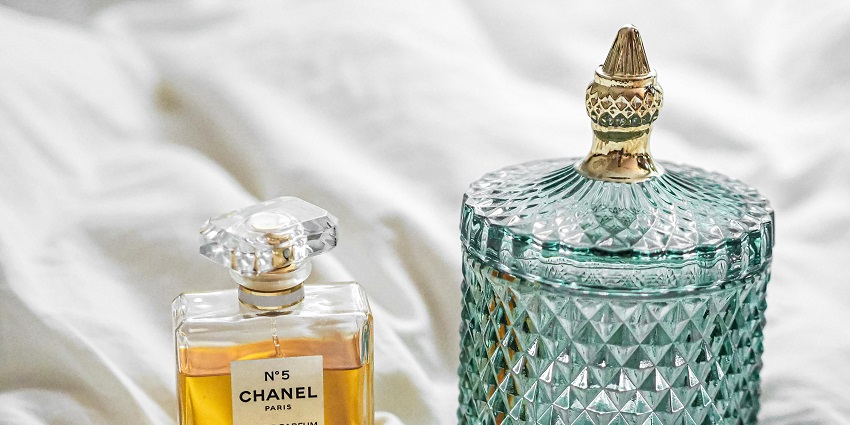 Elegant perfume bottles arranged in warm lighting, with golden caps and luxury branding.
