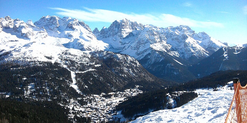 Madonna di campiglio with mountains and distant buildings covered in white snow