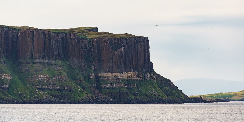 Exploring the Basalt cliff resembling a pleated kilt with a cascading waterfall plunging into the sea is among the best things to do in Skye.