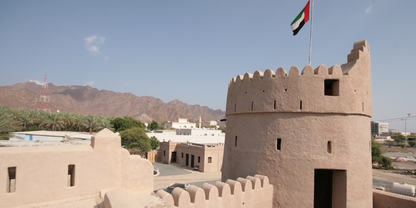 The grand Masafi fort with the local flag flying high on top with the Hajar Mountains seen in the backdrop.