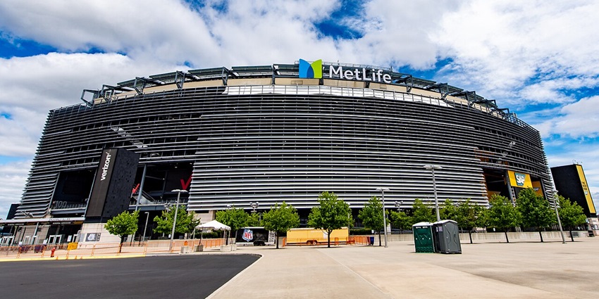 MetLife stadium with modern architecture, multiple signages, street lights and small green trees