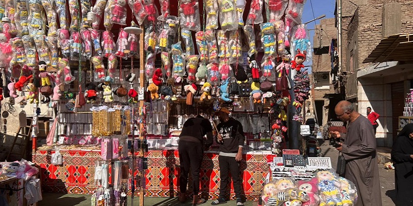 Festive street scene with colourful decorations and a crowd celebrating Moulid An Nabi.