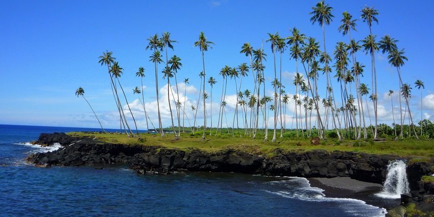 Mu Pagoa Waterfall spilling directly into the ocean over a rocky cliff on the coast of Samoa.