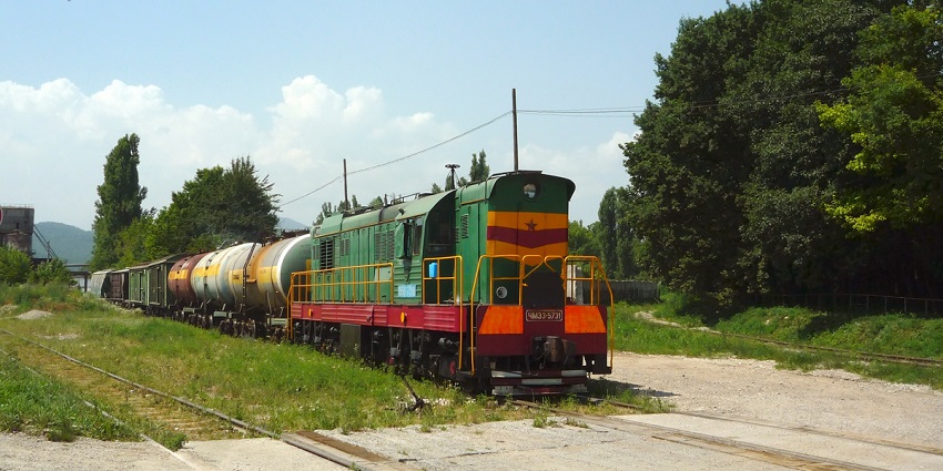 A deserted street of Nalchik with a train on a lush path during the winter in Russia.