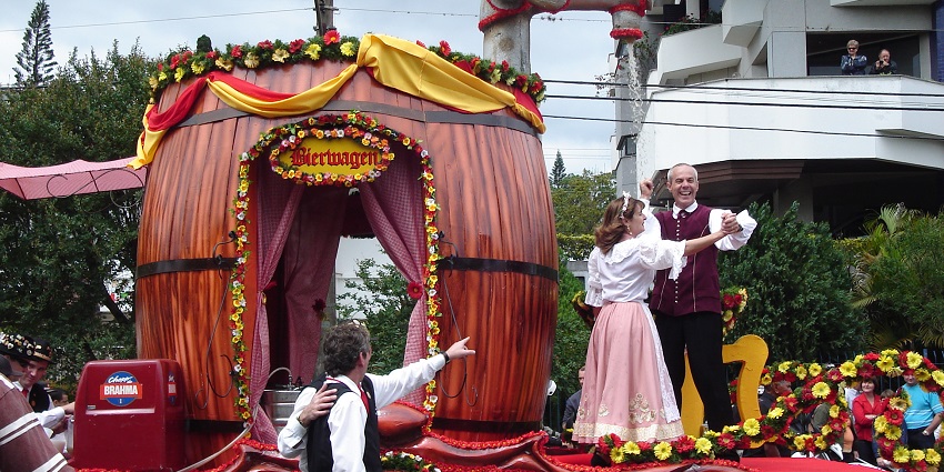 People laughing and performing by standing on a decorated structure for parade