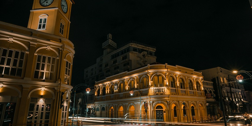 A nighttime view of Old Phuket Town featuring a majestic building with a clock tower.