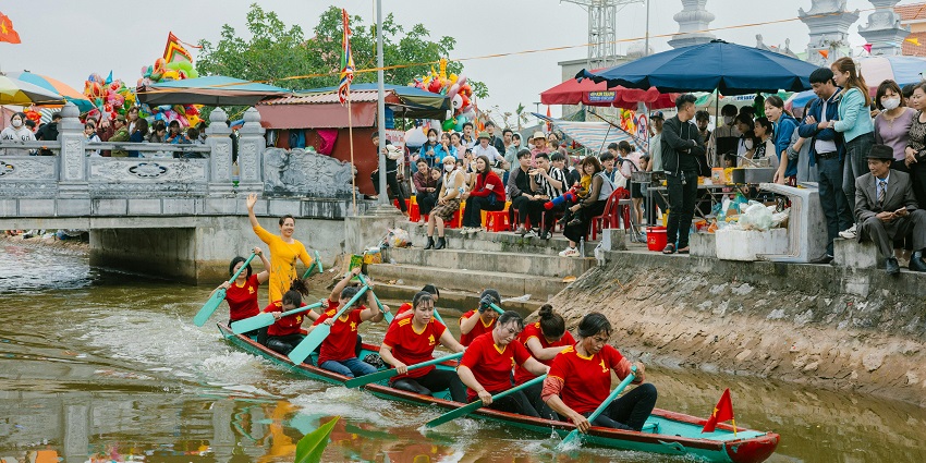 An image of group of women rowing a long boat in a traditional boat race on a scenic river.