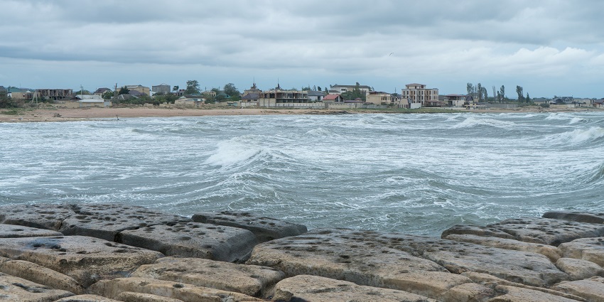 An image of the shoreline of the Caspian Sea, under a cloudy sky with splashing waves