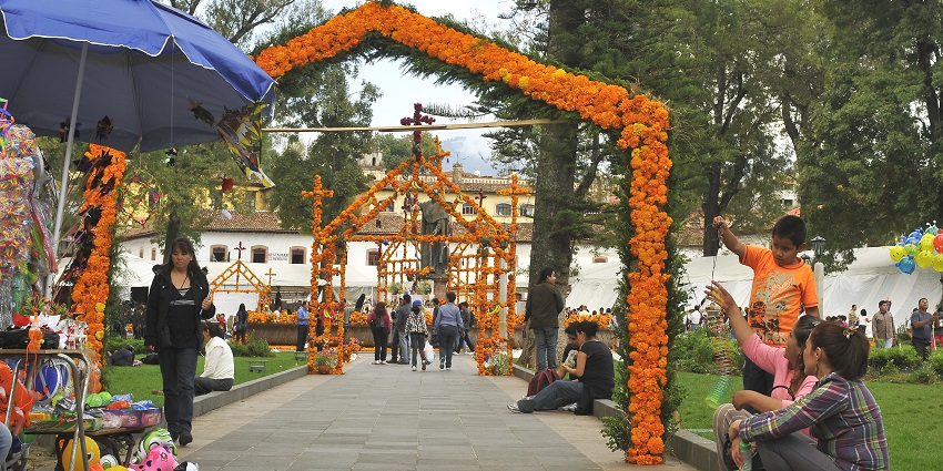 Pátzcuaro plaza decorated with marigolds and people sitting and walking around