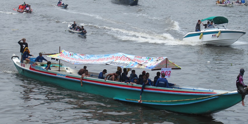 Boats filled with people are participating in a lively boat parade in the Pagoda festival.