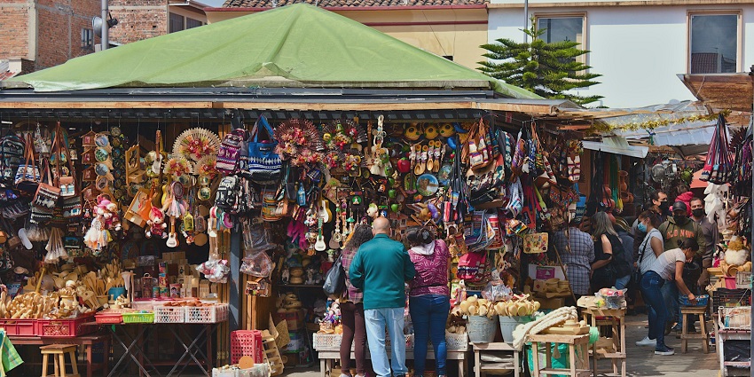Busy scene at Poorna Market with stalls selling fresh produce and daily essentials.
