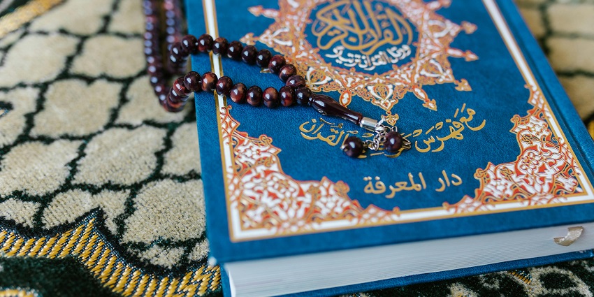 An image of colourful prayer beads (Misbaha) made of wood, glass, and gemstones.