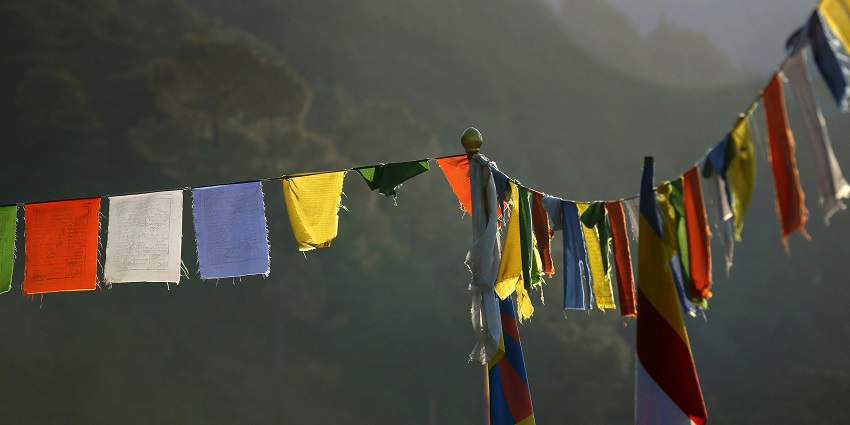 An Image of colourful prayer flags, a meaningful item to buy in Nepal, folded and ready for sale.