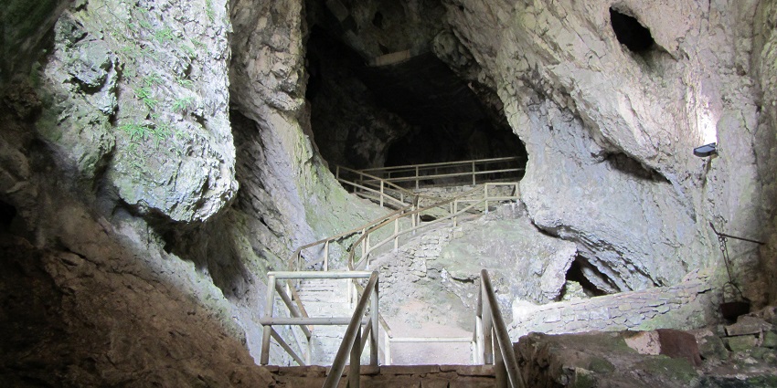 An image of the Predjama Cave behind the Predjama Castle in Slovenia caves, showcasing its unique location.