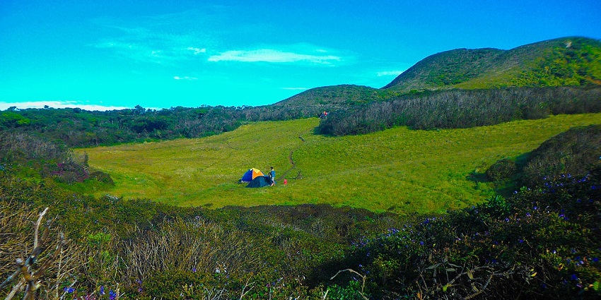 A man sets a camp amidst lush, rolling hills of Pussellawa, perhaps a perfect spot for a lazy day.