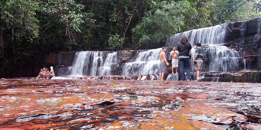A group of visitors enjoy the crystal clear waters of Quebrada de Jaspe in Venezuela