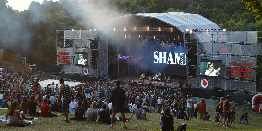 A singer in full action on the stage during a musical concert with all the fireworks at the backdrop.