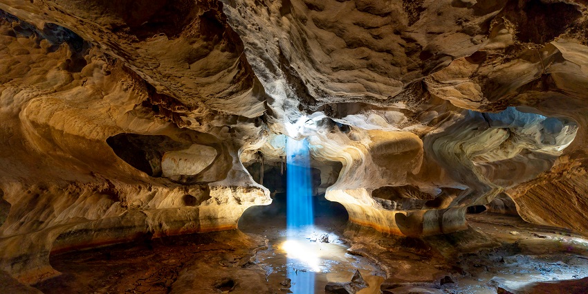 Sunlight streams into a cave in Kien Giang, Vietnam, illuminating ancient formations
