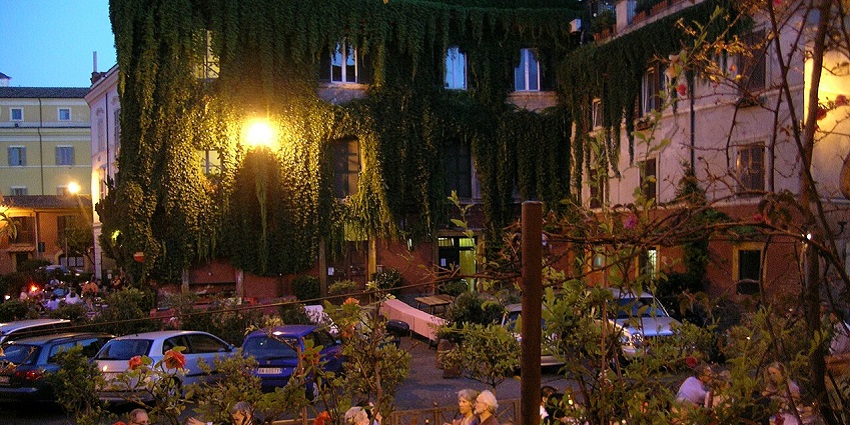 Restaurant in Rome's Trastevere district, featuring outdoor seating under green canopies