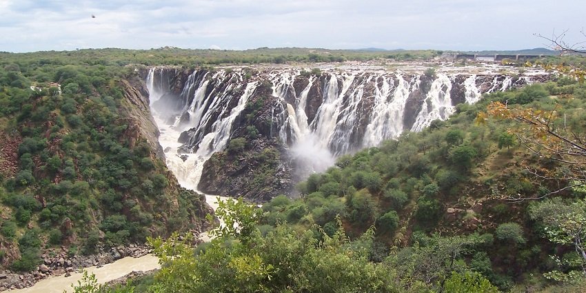 Ruacana Falls with water cascading down rocks surrounded by a rocky landscape.