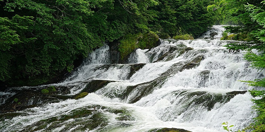 Ryuzu Falls are layered waterfalls in Japan, surrounded by lush greenery in a serene setting