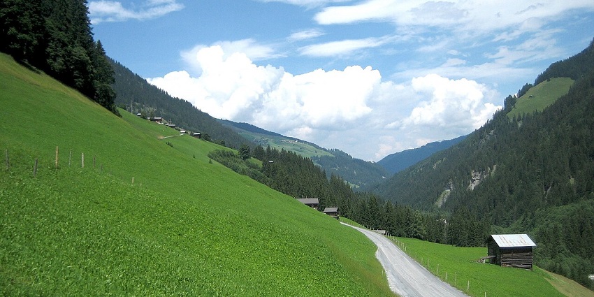 Safiental valley with a shed near the edge and a narrow pathway passing through the valley