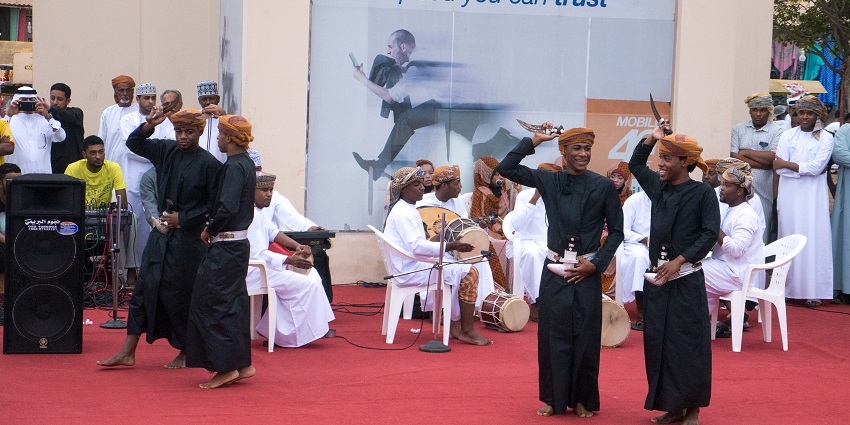 Omani men performing traditional music and dance at the Salalah Festival in Oman.
