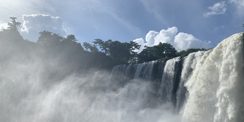Salto de Eyipantla waterfall crashes into a rocky basin, surrounded by dense green forest.