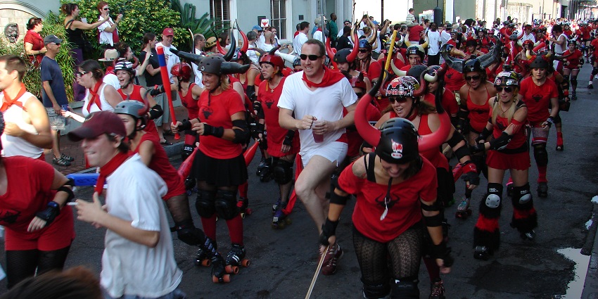 People in red and white running through the streets during the San Fermin-style festival event.