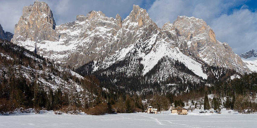 San Martino di Castrozza with small distant huts and rocky mountains covered in snow