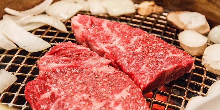 A premium marbled Kobe beef grilling, showcasing one of the top culinary experiences and must-try things to do in Kobe.