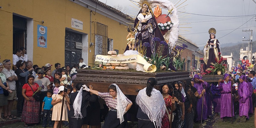 Processions of hooded worshippers carry religious statues through colonial streets during Semana Santa.