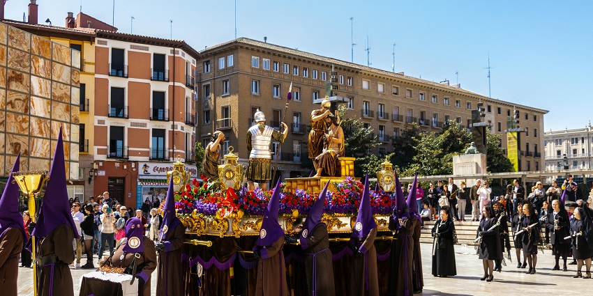 People gather to witness the Holy Week procession with a statue of Christ carrying the cross.