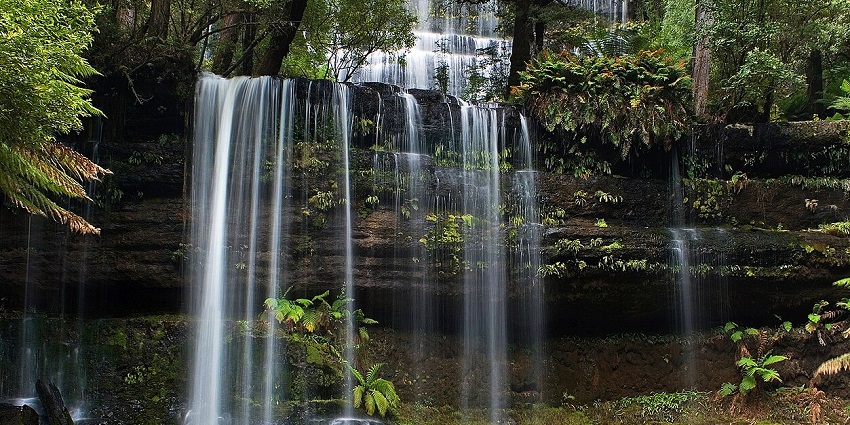 A scenic waterfall steeped in legend and spiritual significance, surrounded by lush greenery.