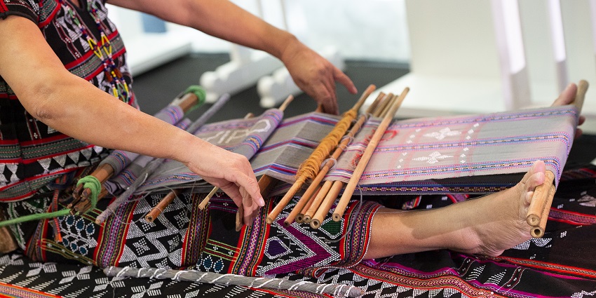 An image of a person making silk products, which is among the popular things to buy in Vietnam.